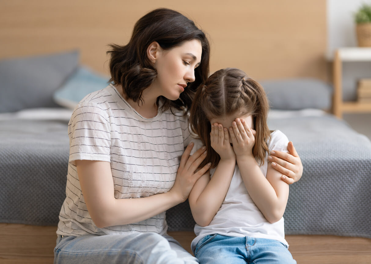 madre abraza hija triste que llora en el suelo consuelo