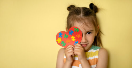 nina con corazon piezas de colores simbolo de autismo