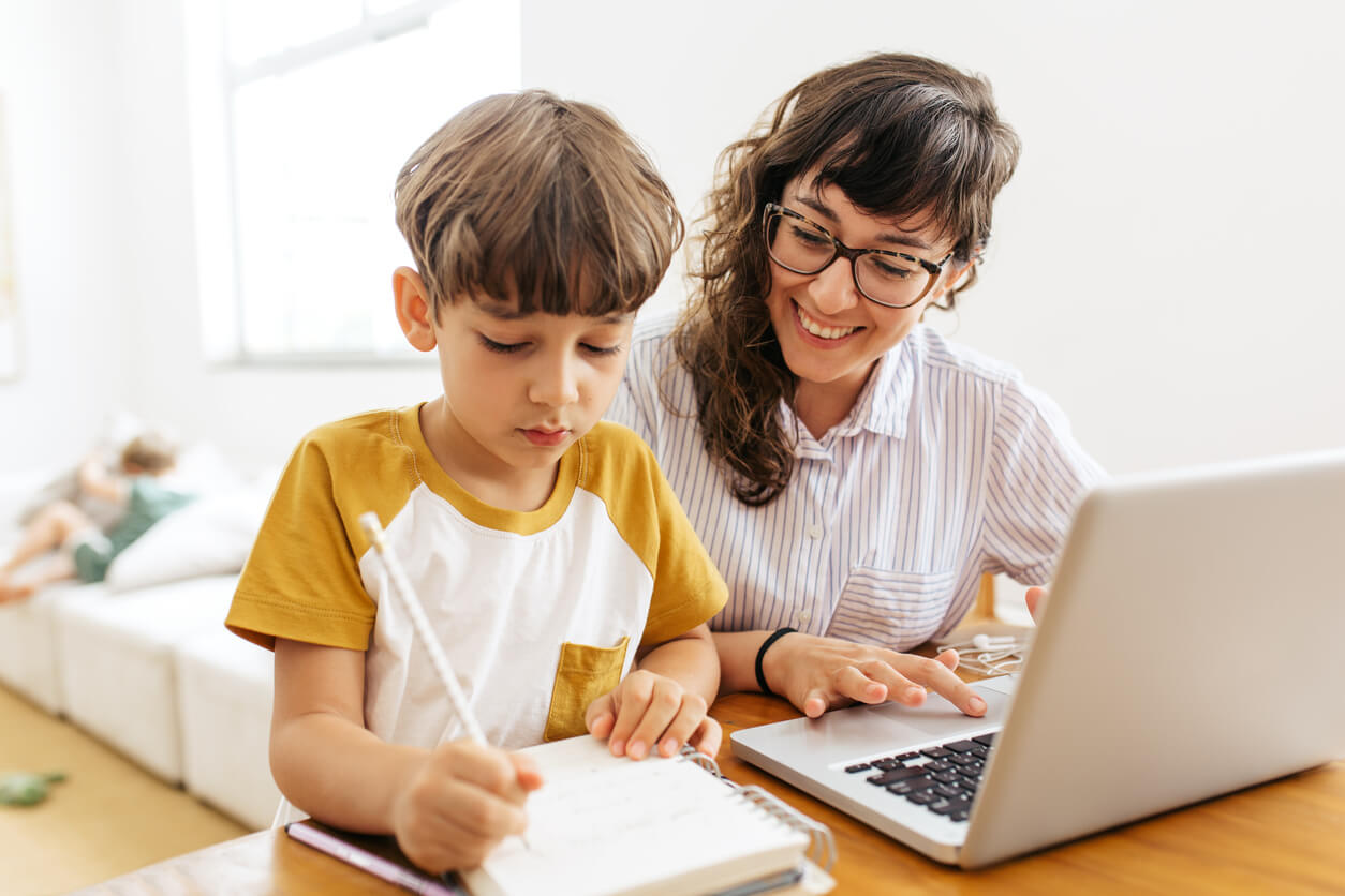 mère et fils font leurs devoirs avec un crayon pour ordinateur portable et un ordinateur portable