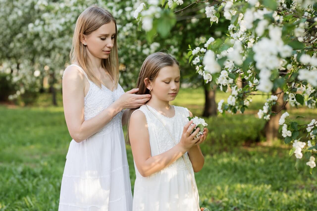 Une jeune maman et sa fille dans un jardin.