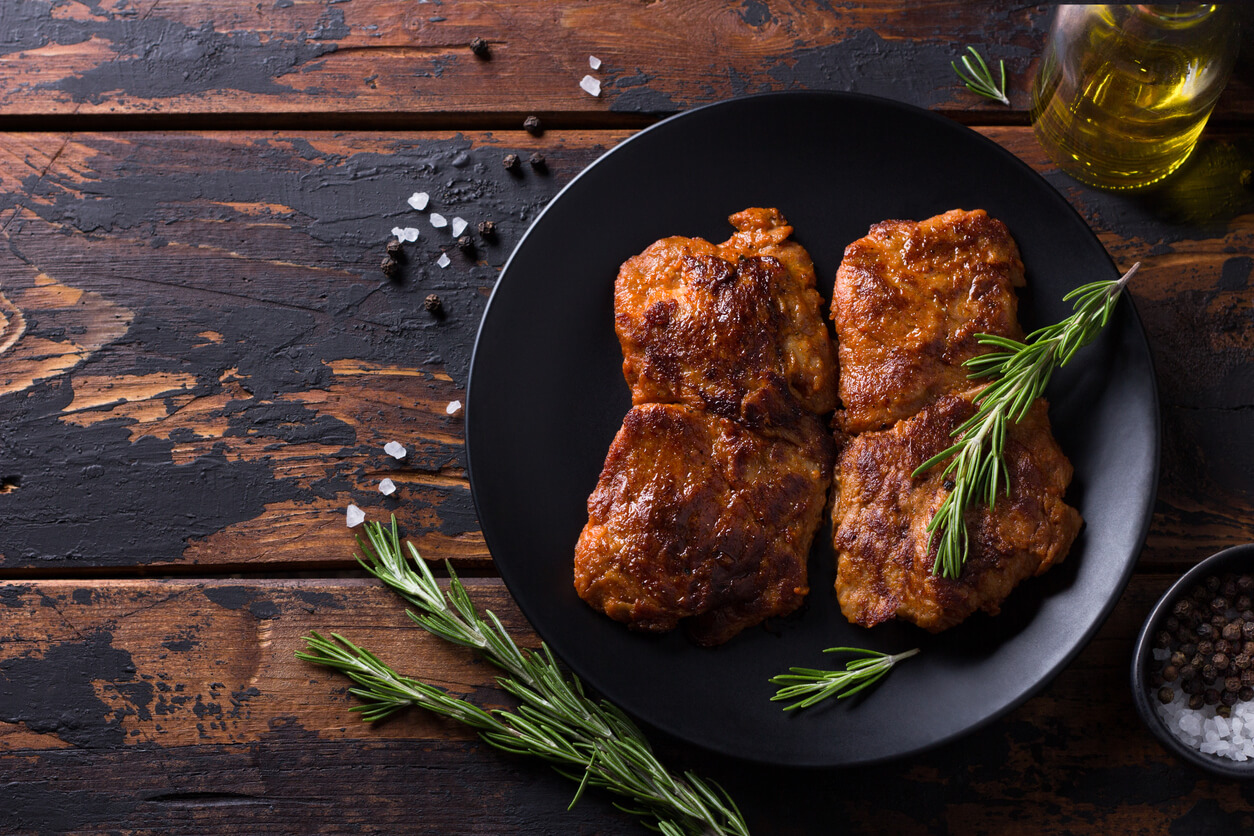 Bistecca di soia russa su tavola di legno con rametti di rosmarino e olio d'oliva