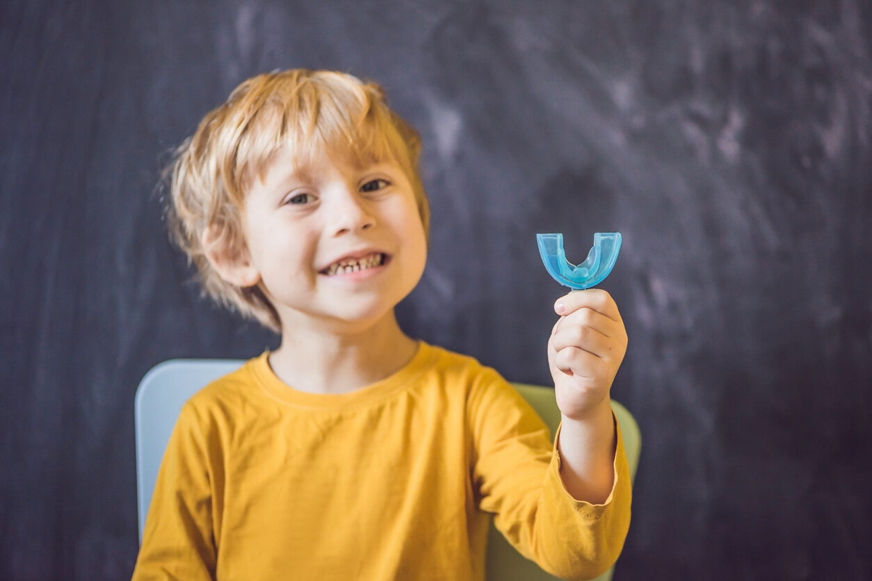 A child holding a dental splint.