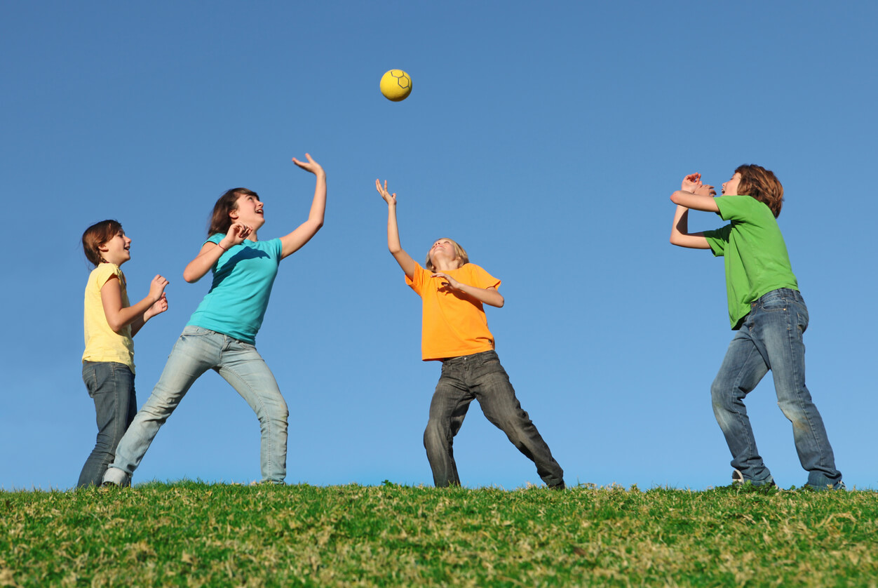 les enfants jouent au ballon avec leurs mains dans le parc
