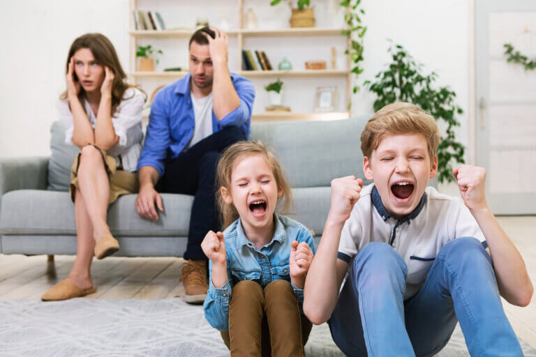 Des parents excédés à côté de leurs enfants qui crient;
