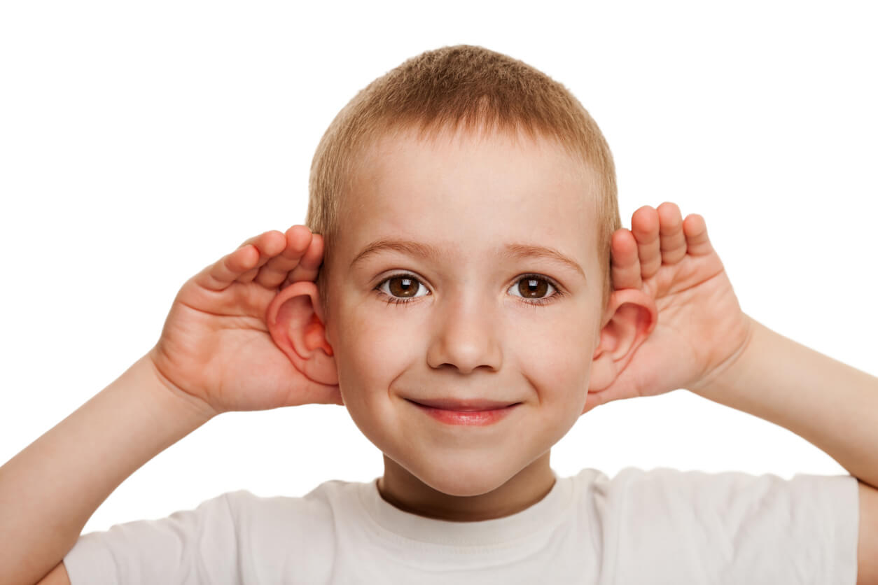 A child with his hands behind his ears.