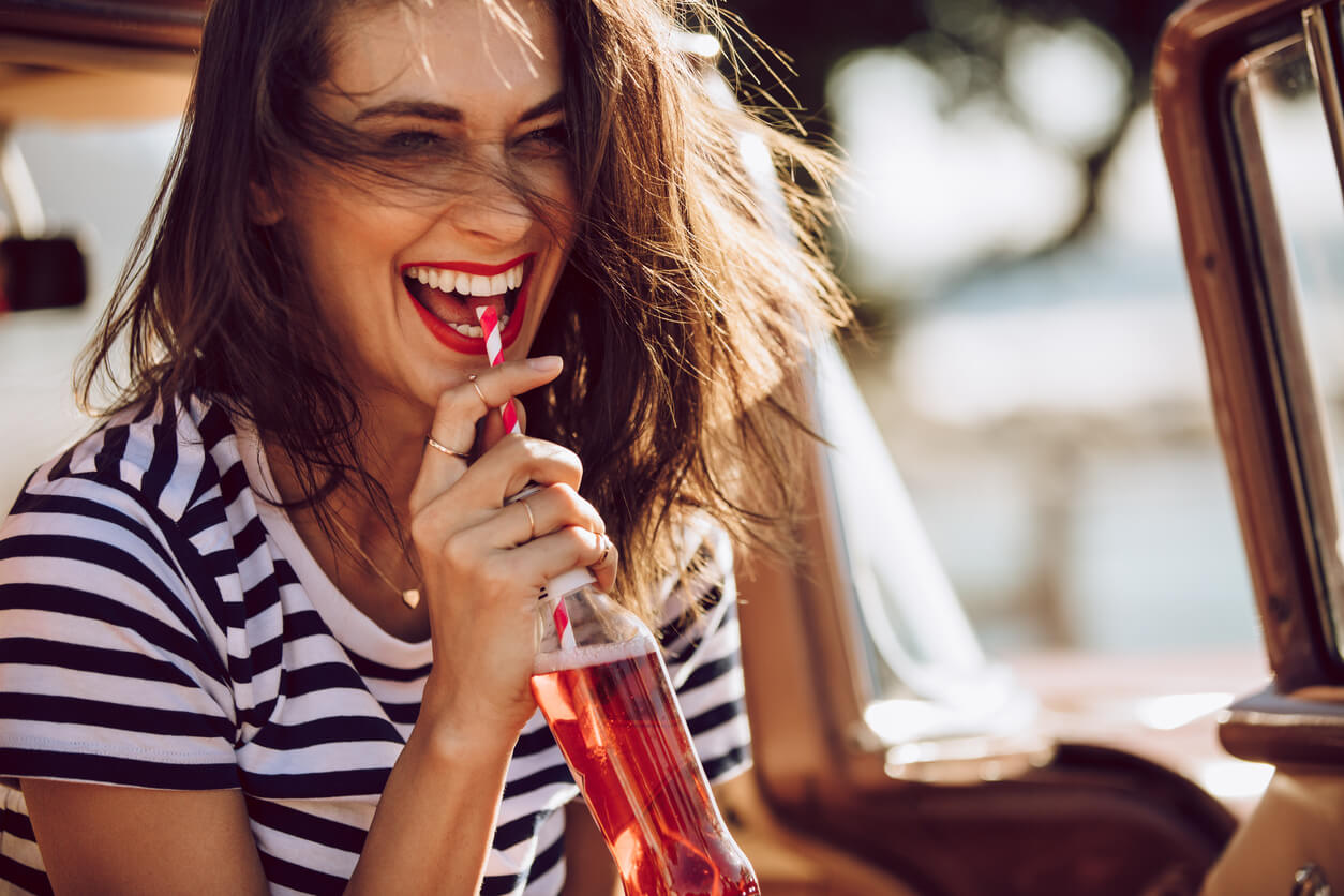 A teen drinking a soft drink.