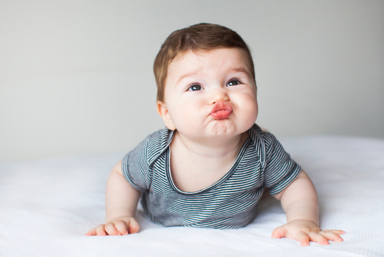 Un bébé qui fait un bisou avec sa bouche.