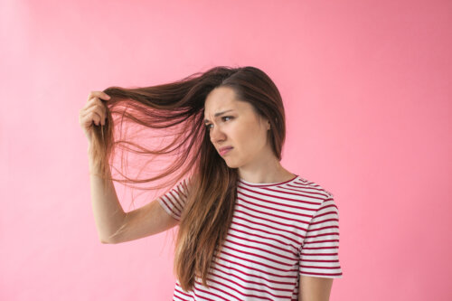 mujer se toma el cabello poco saludable