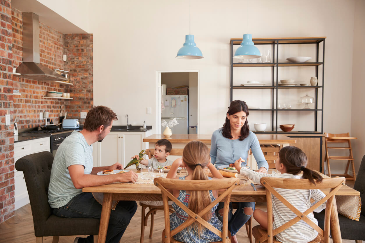 madre padre ragazze bambino mangiare insieme a tavola di famiglia abitudini sane