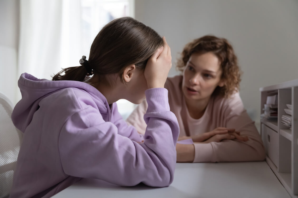 A mother talking to her teenage daughter, who looks overwhelmed.