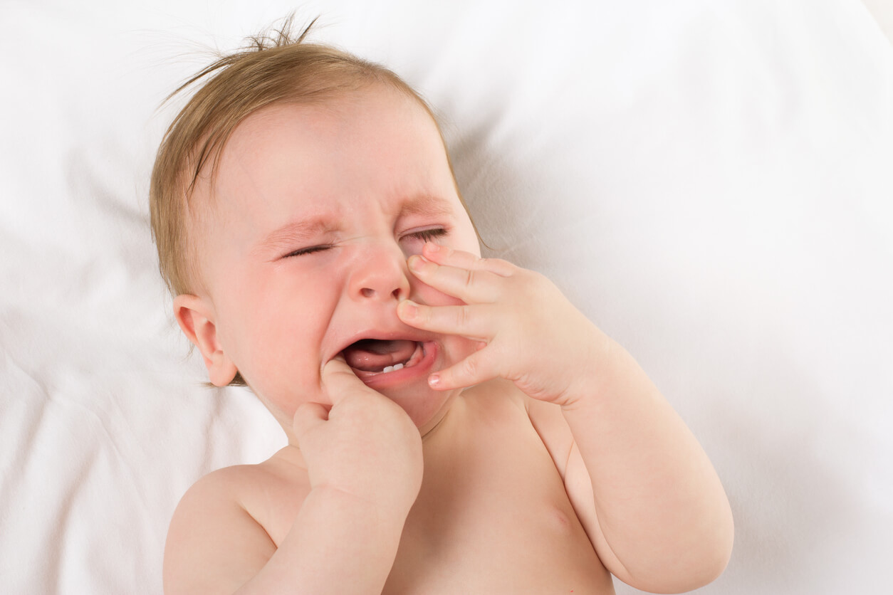Un bébé qui pleure car il a mal aux dents.