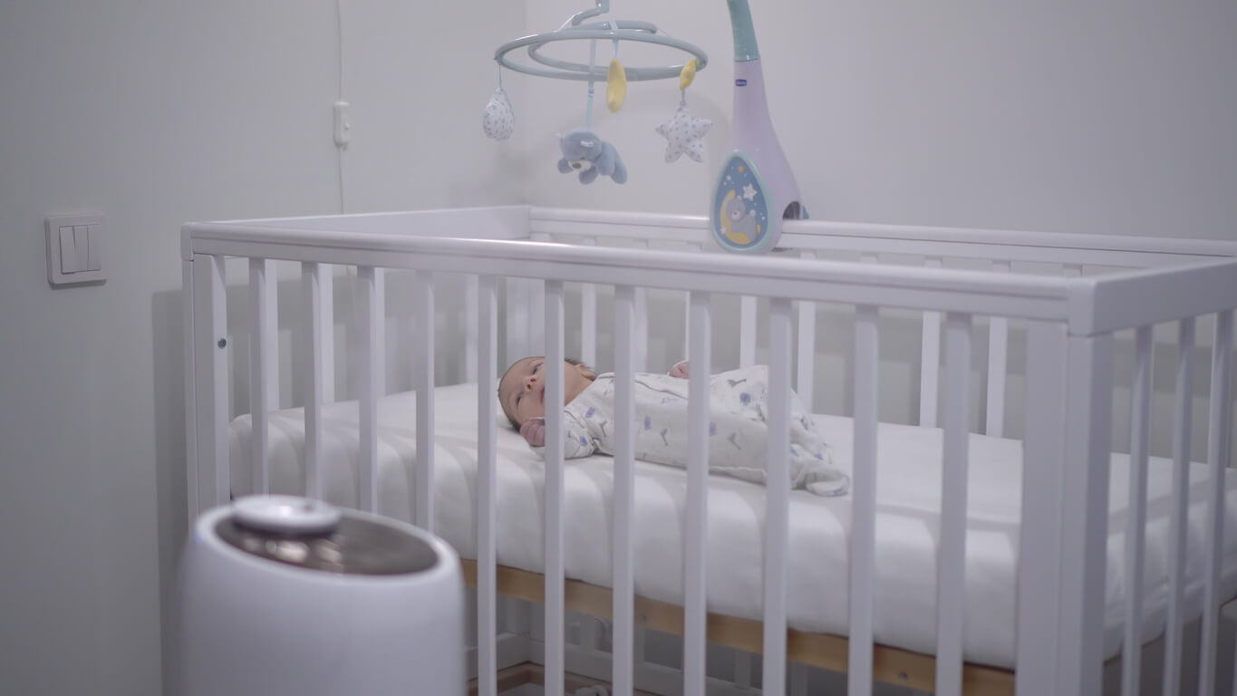 Un bébé qui dort à côté d'un vaporisteur.