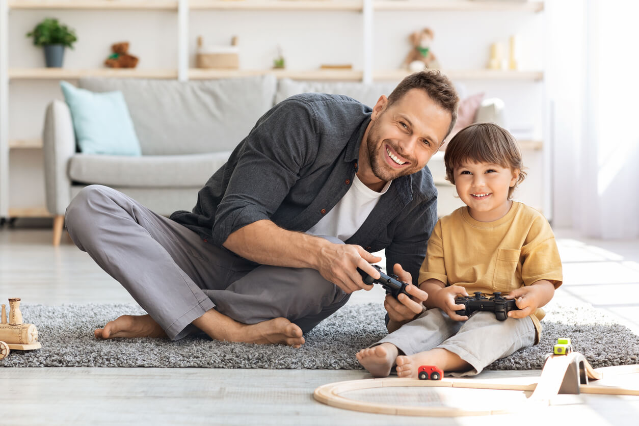 Un papa qui joue avec son fils aux jeux vidéo.