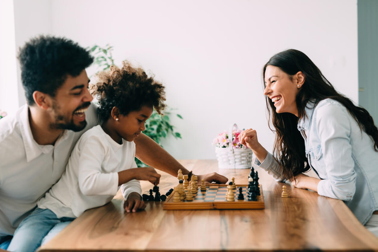 A family enjoying a game of chess inside their home.