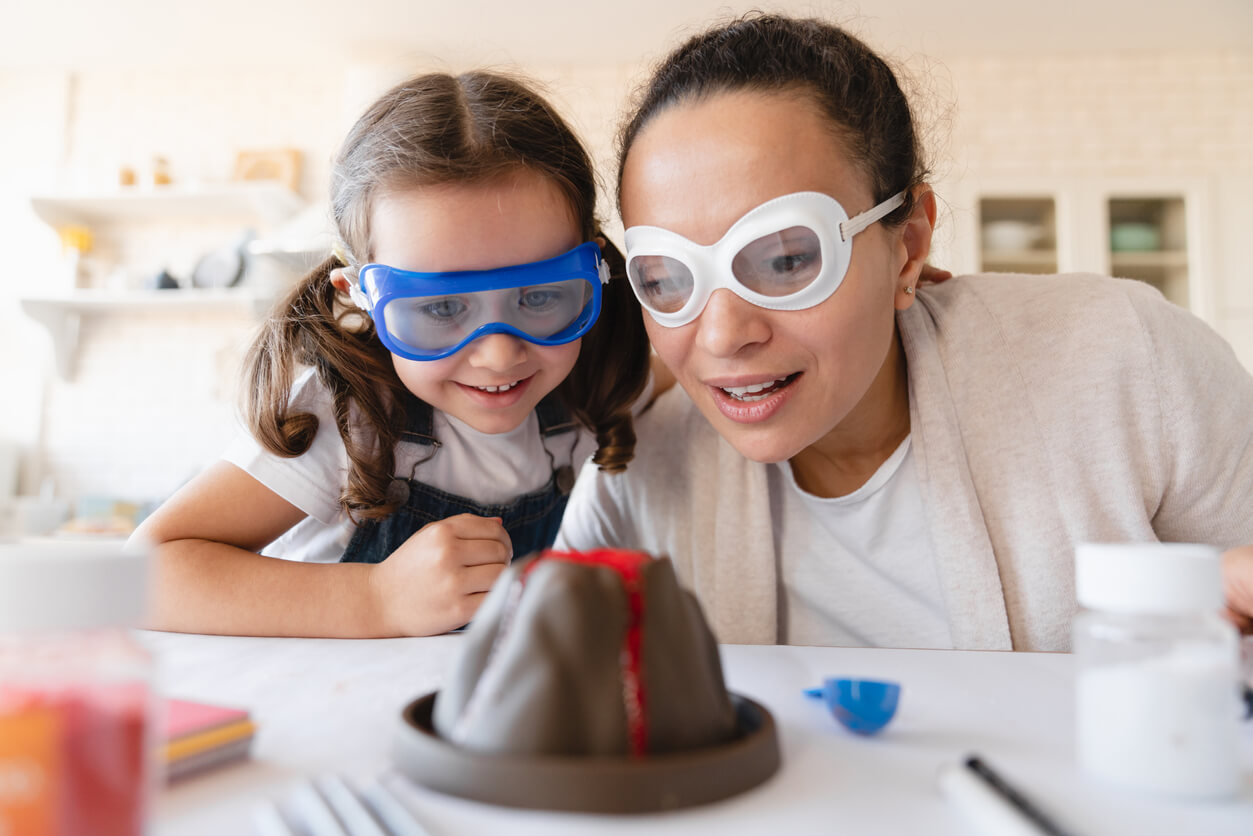 A mother and daughter doing a scientific experiment with a mini volcano.