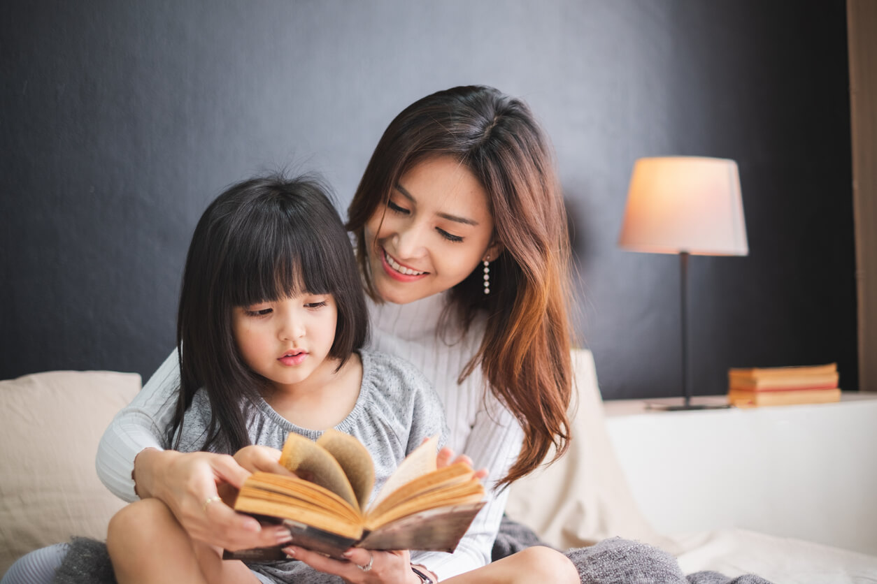 Une maman qui lit un livre à sa fille.