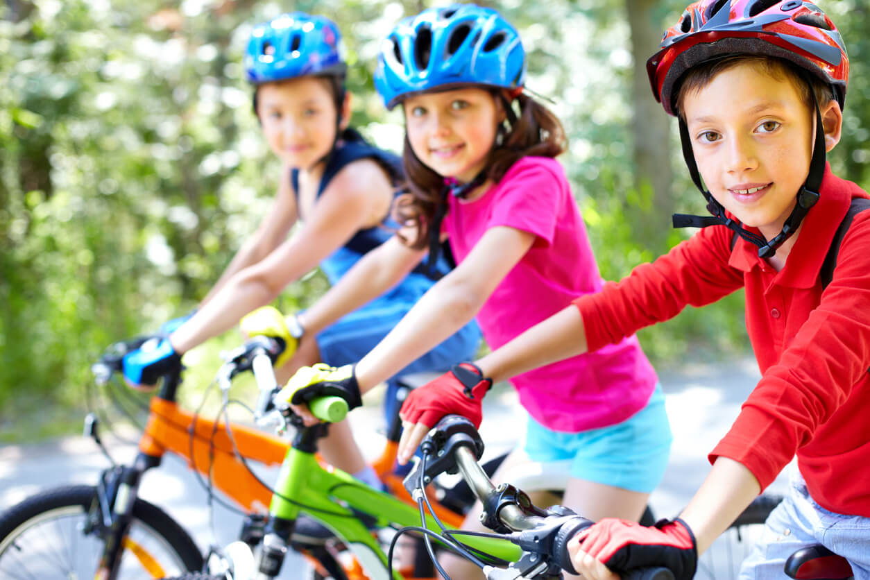 Children riding bikes, wearing helmets.