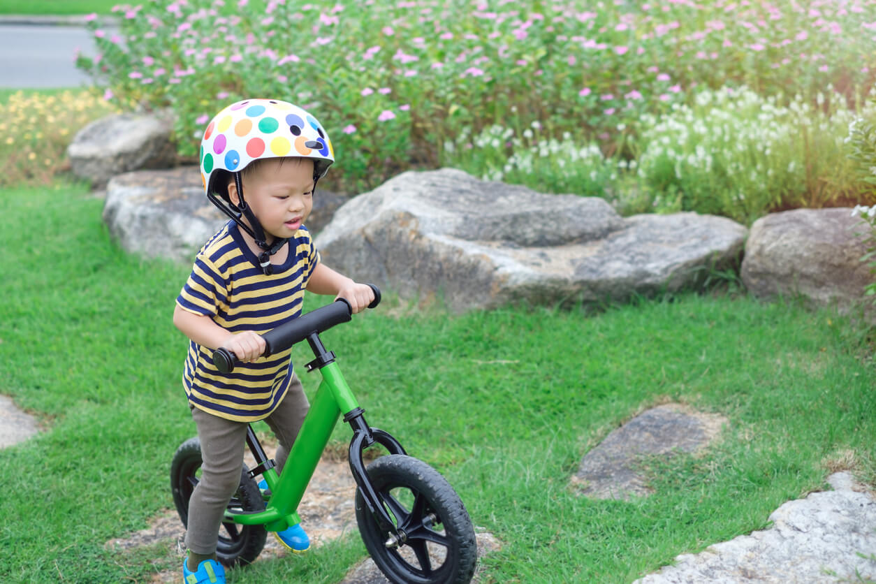 A toddler using a bike without pedals.