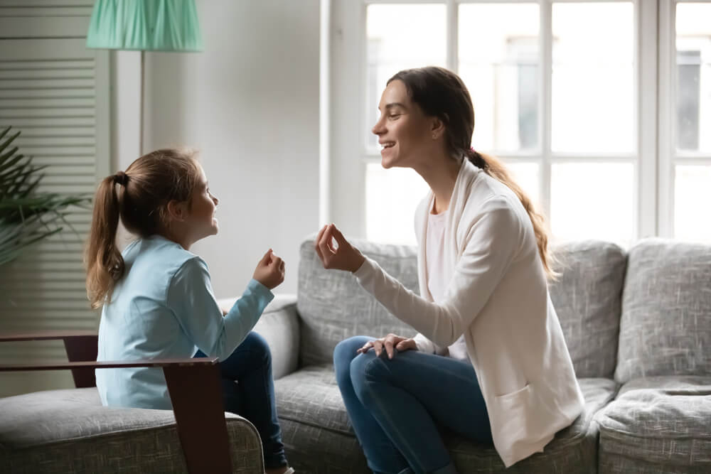 A mother dialoguing with her young daughter.