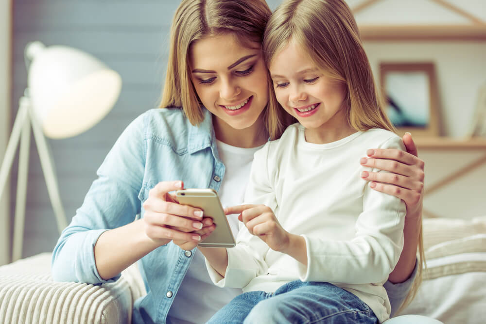 Une mère et sa fille sur un téléphone. 