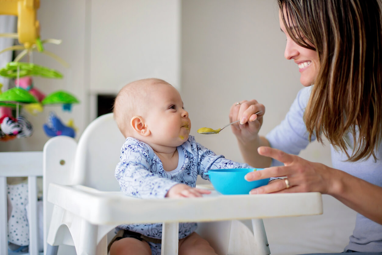 A mother spoonfeeding her baby.