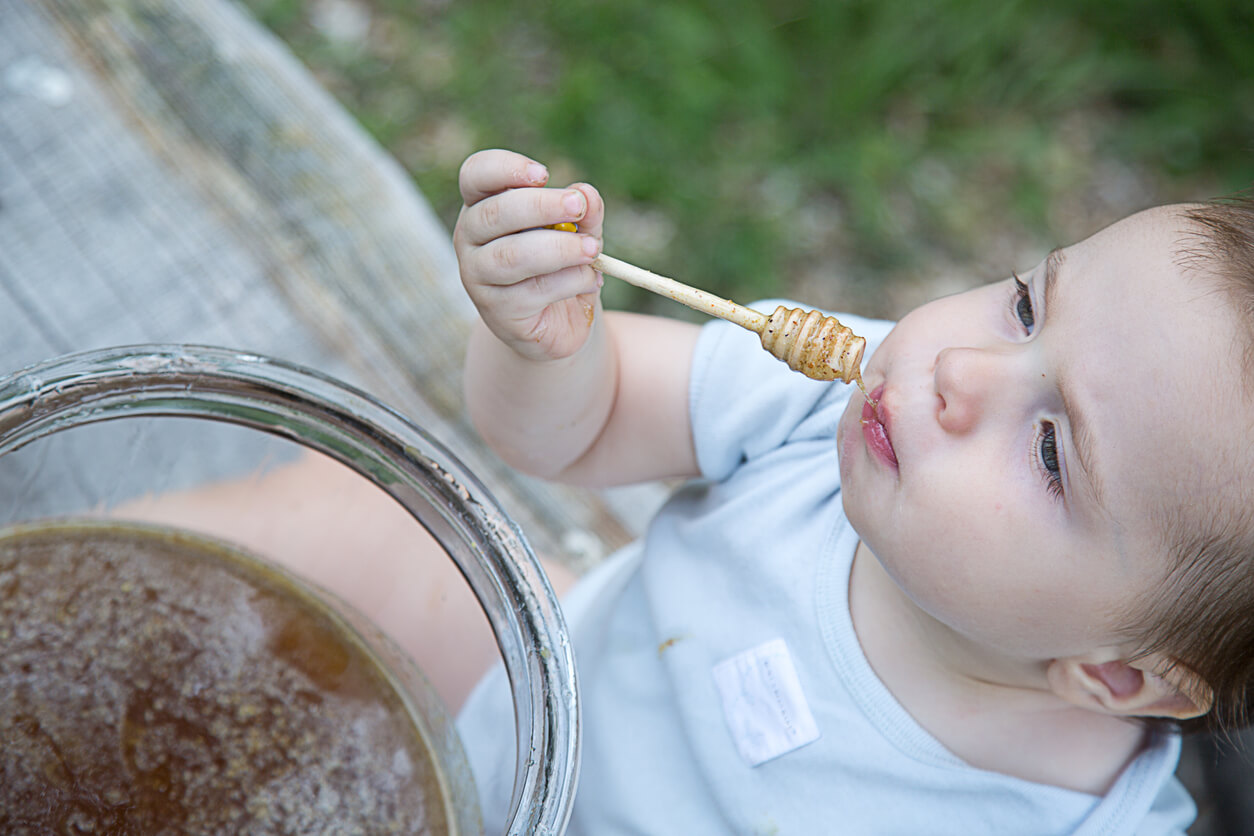 A baby trying honey.