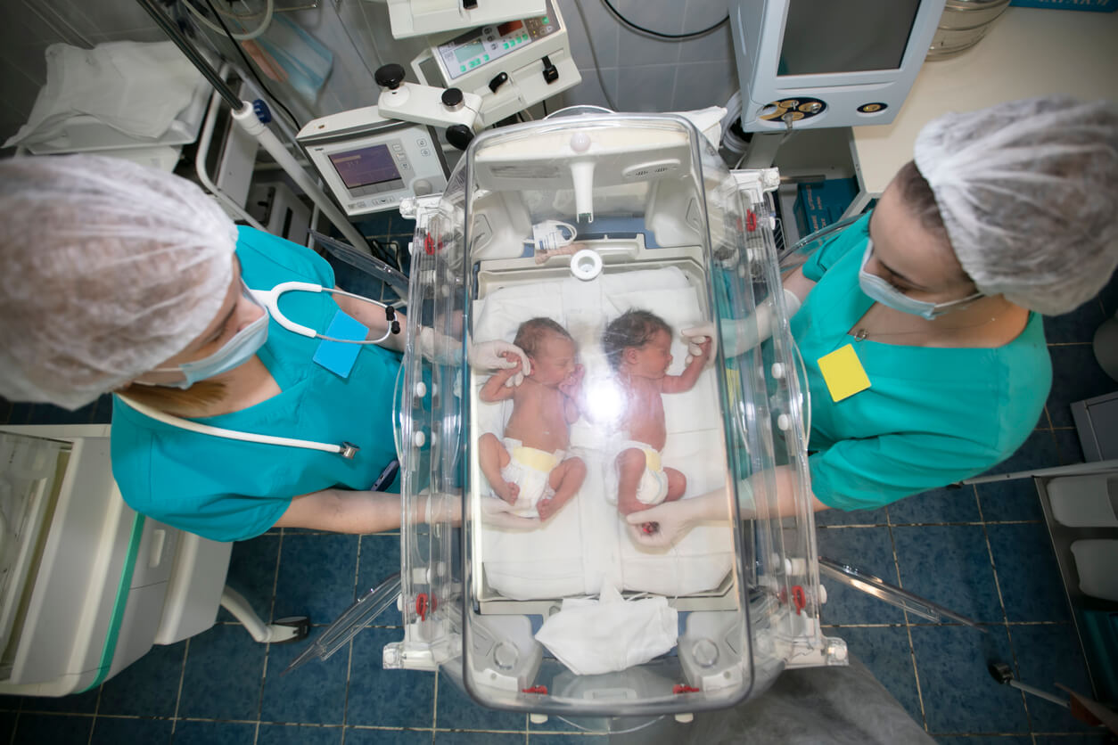 Sjuksköterskor som tar hand om nyfödda tvillingar.