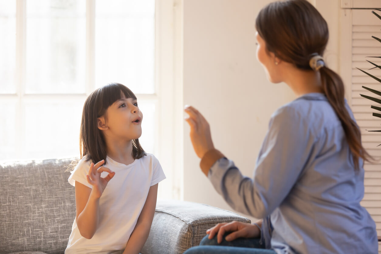 A young girl working with a speech therapist.
