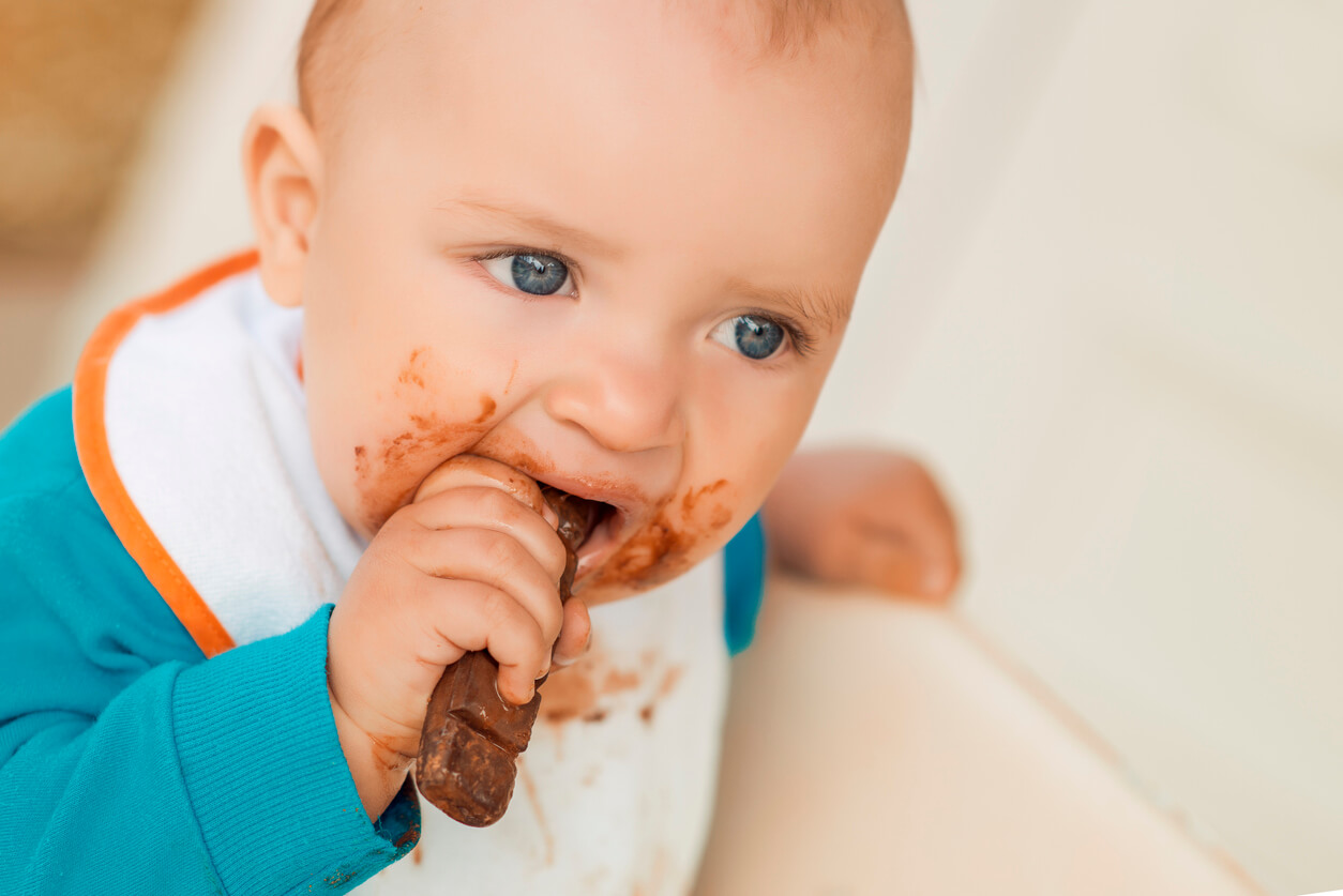 En bebis som äter en chokladkaka.