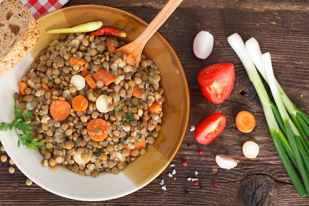 A bowl of lentils with vegetables.