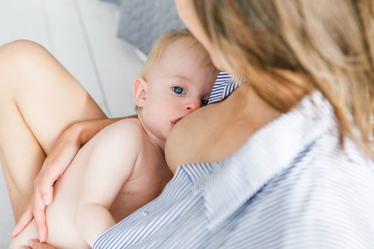 A mother holding her baby while breastfeeding.