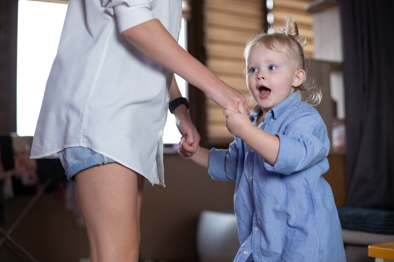 En mor som danser med 1-åringen sin.