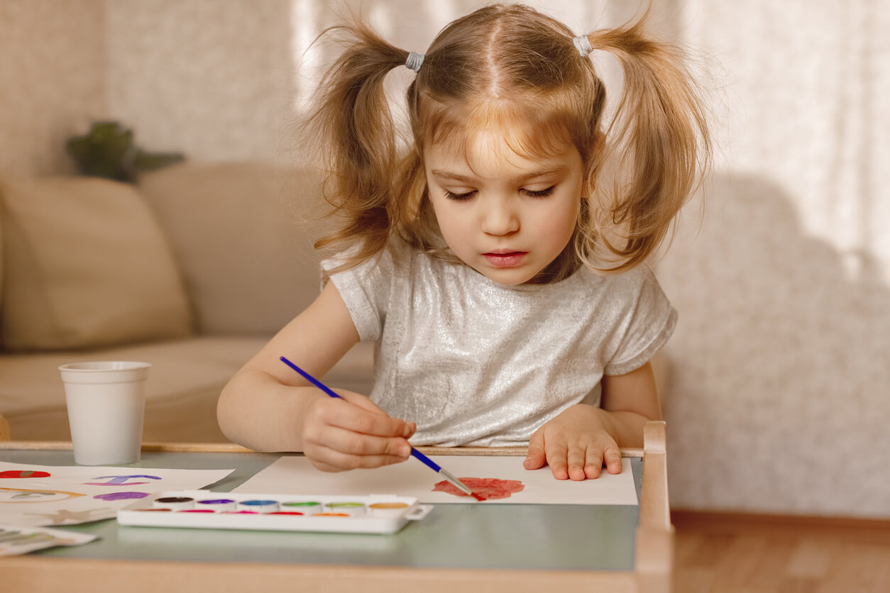 A young girl painting with water colors.