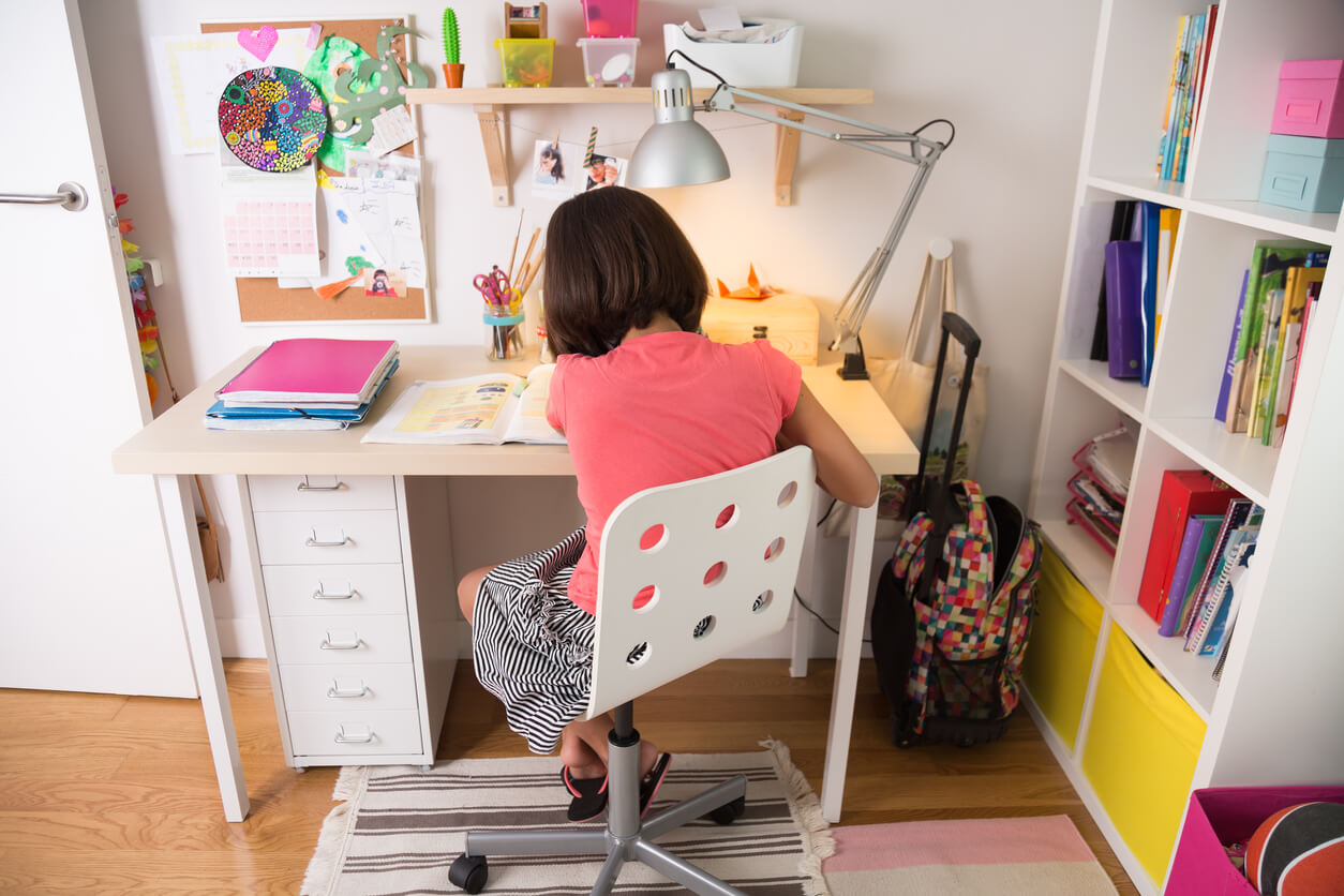 Une jeune fille qui travaille à son bureau.