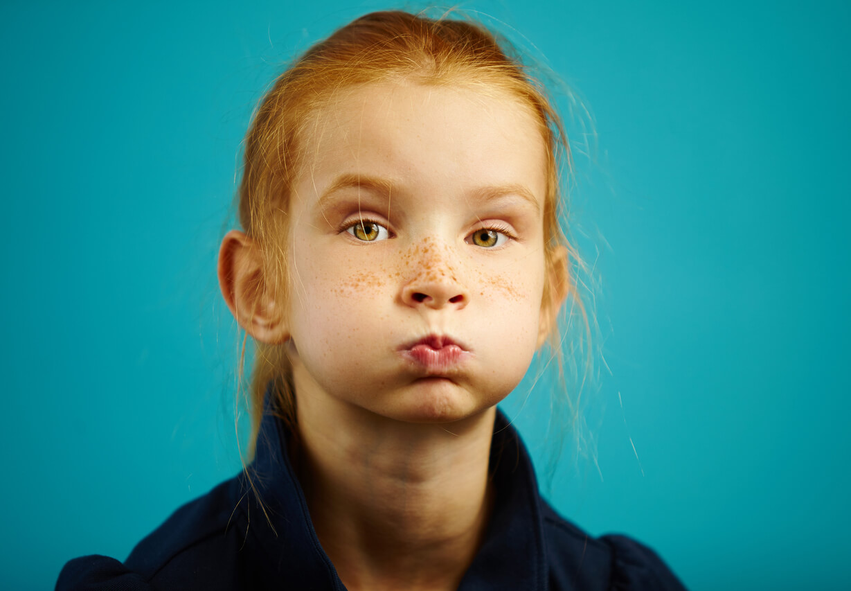 Une jeune fille avec les joues gonflées d'air.