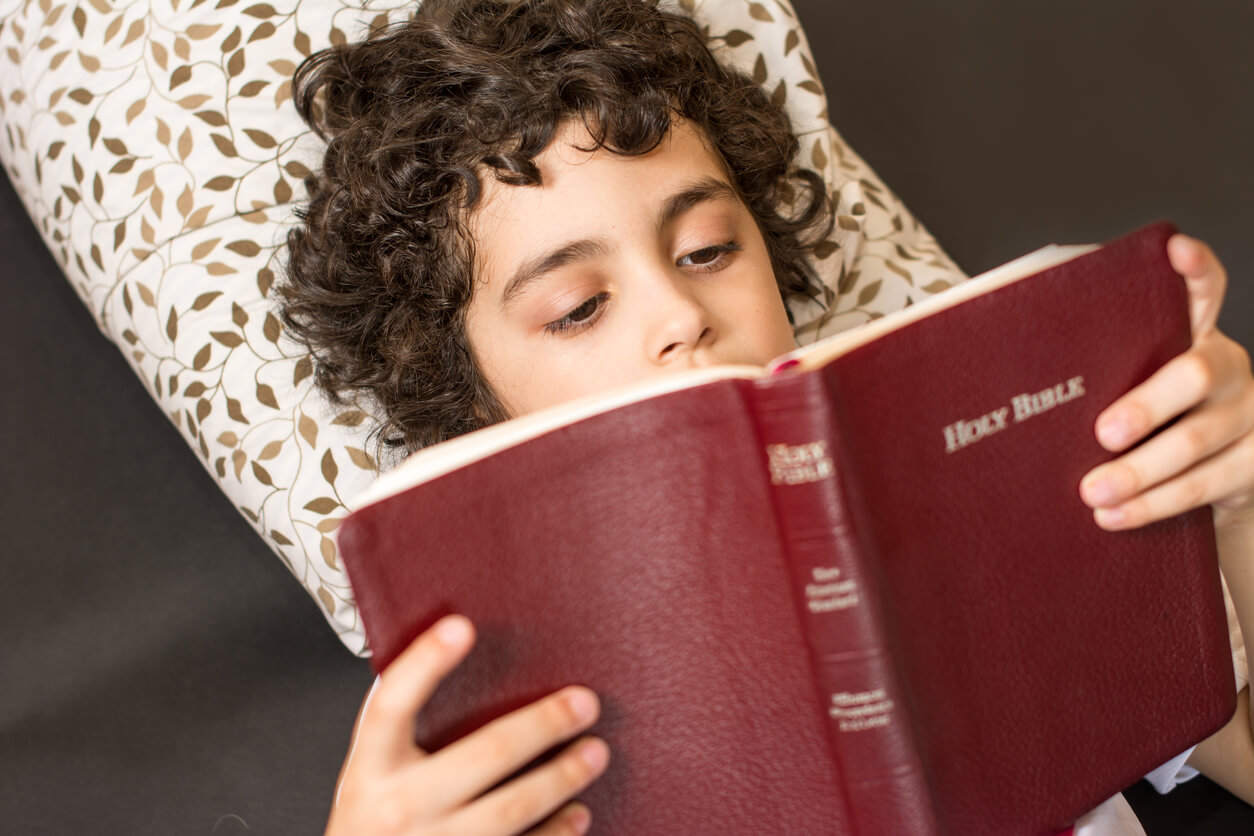 A young boy reading the Bible.