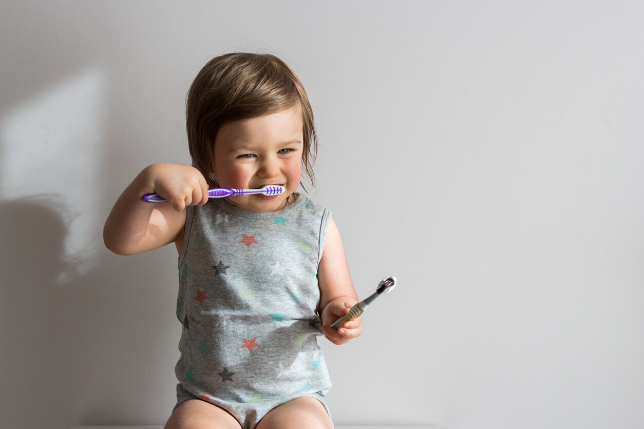 A toddler brushing her teeth.