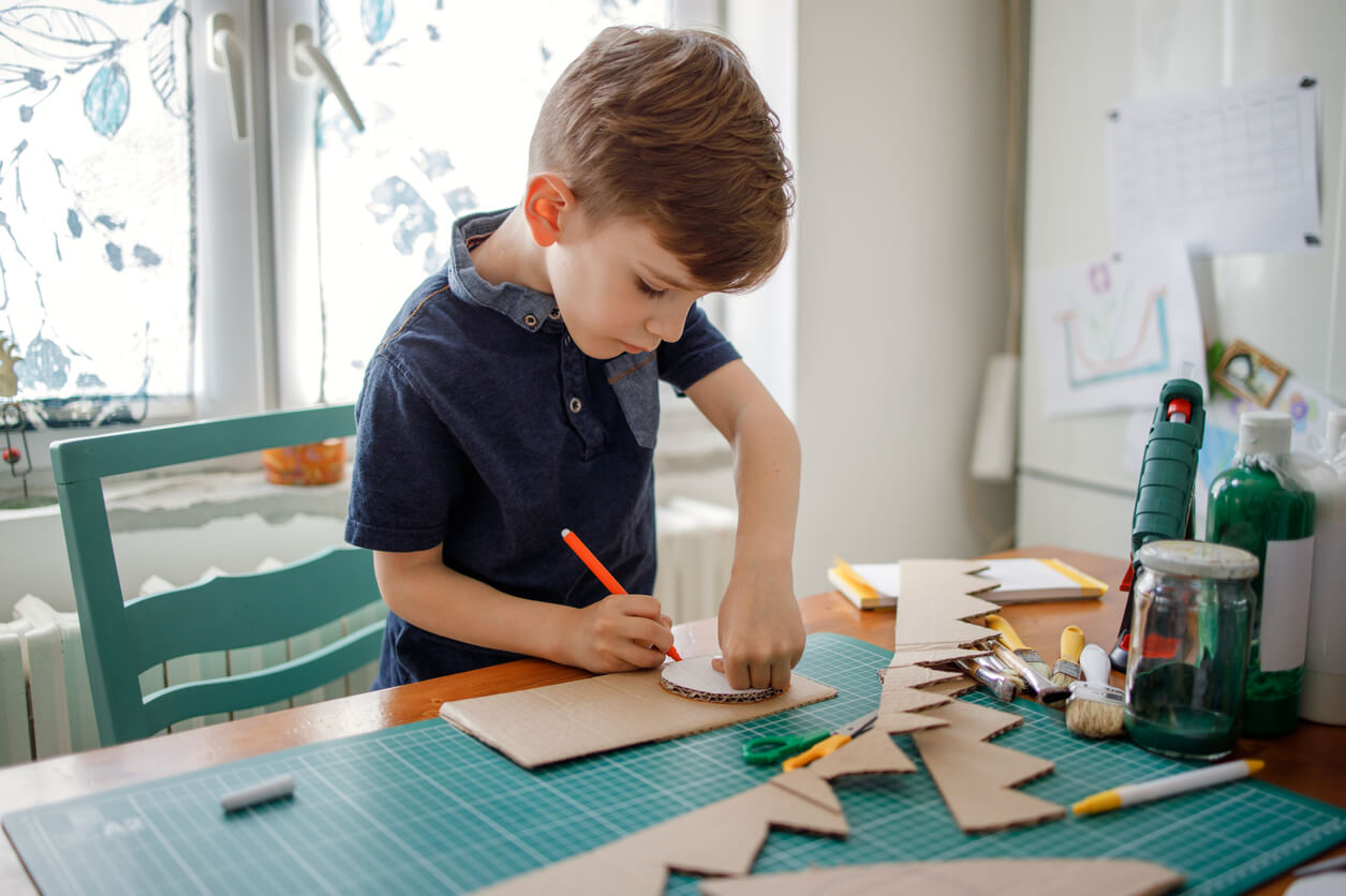 Et barn lager et håndverk med papp.