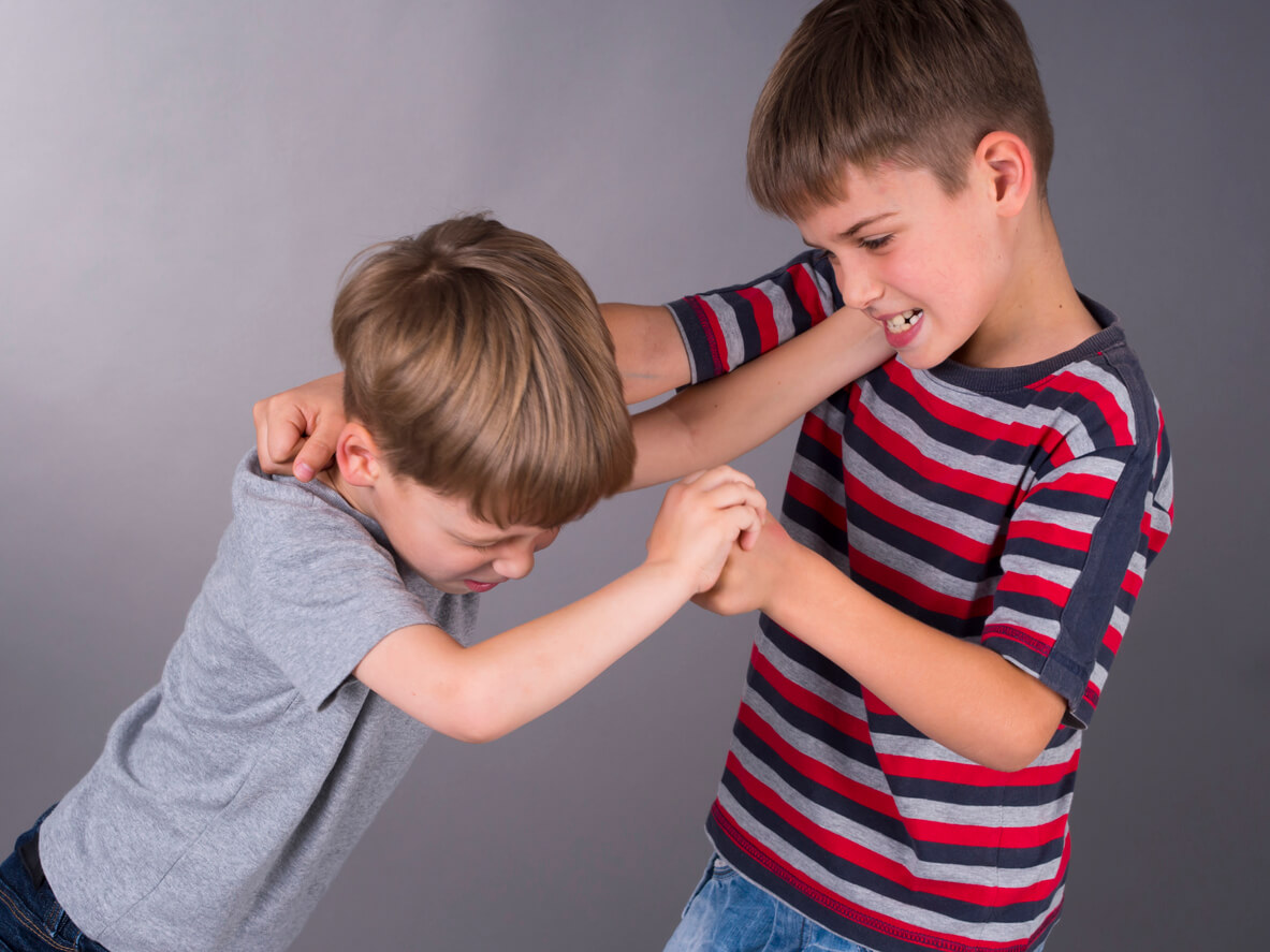 Two boys fighting aggressively.