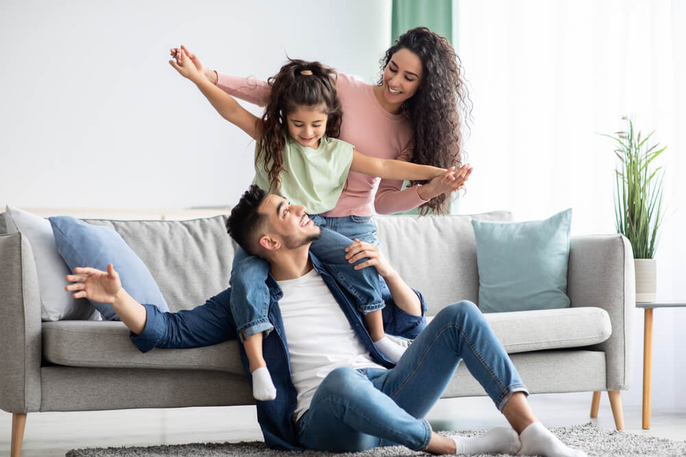 Deux parents qui jouent avec leur fille.