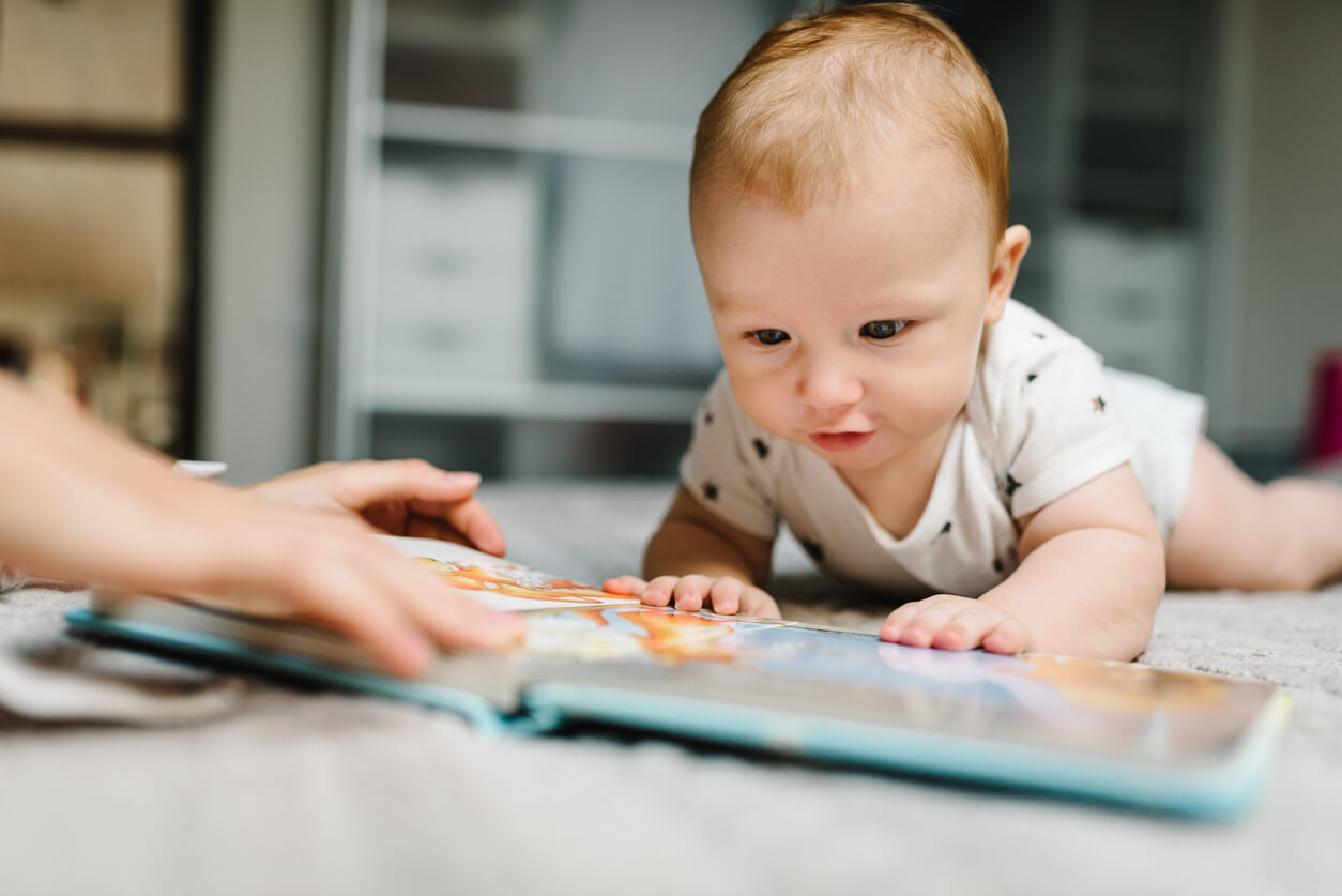 Un bébé qui regarde un livre.