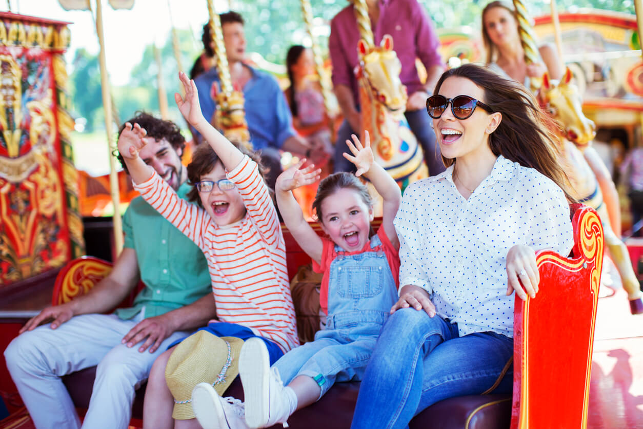 A family riding on a carousel in an amusement park.