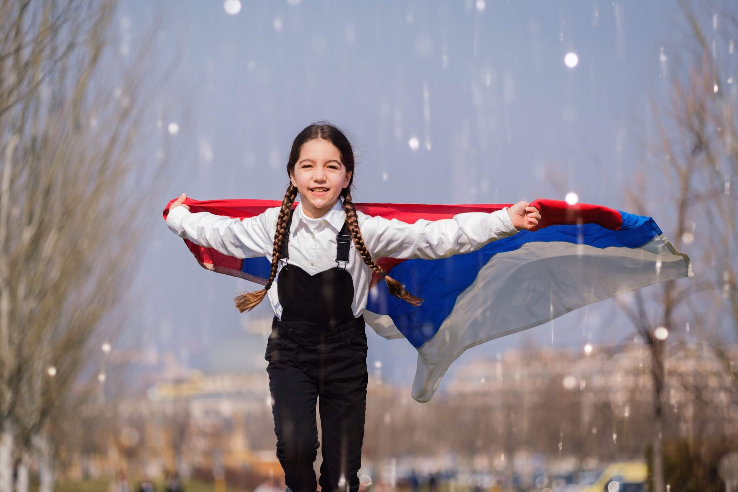 A girl running while holding onto a Russian flag.