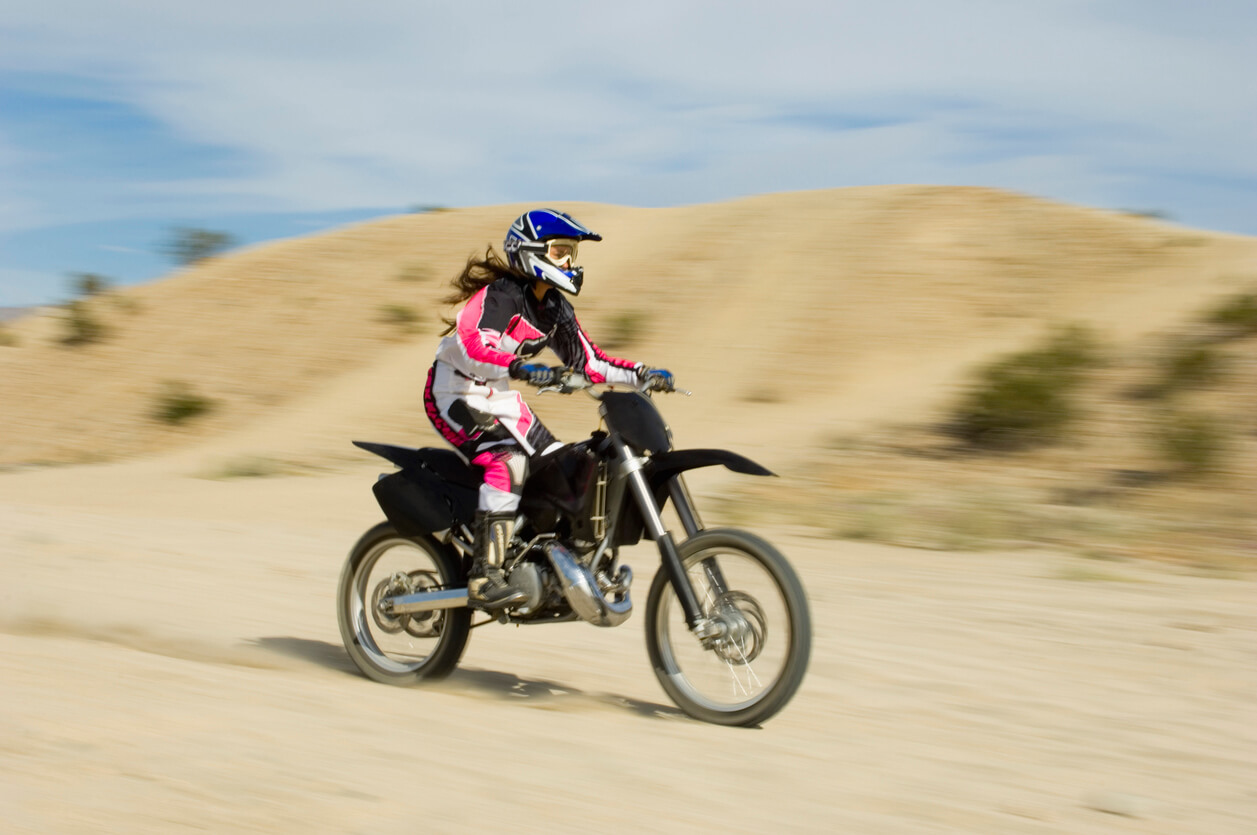 A teenage girl riding a motorcycle.