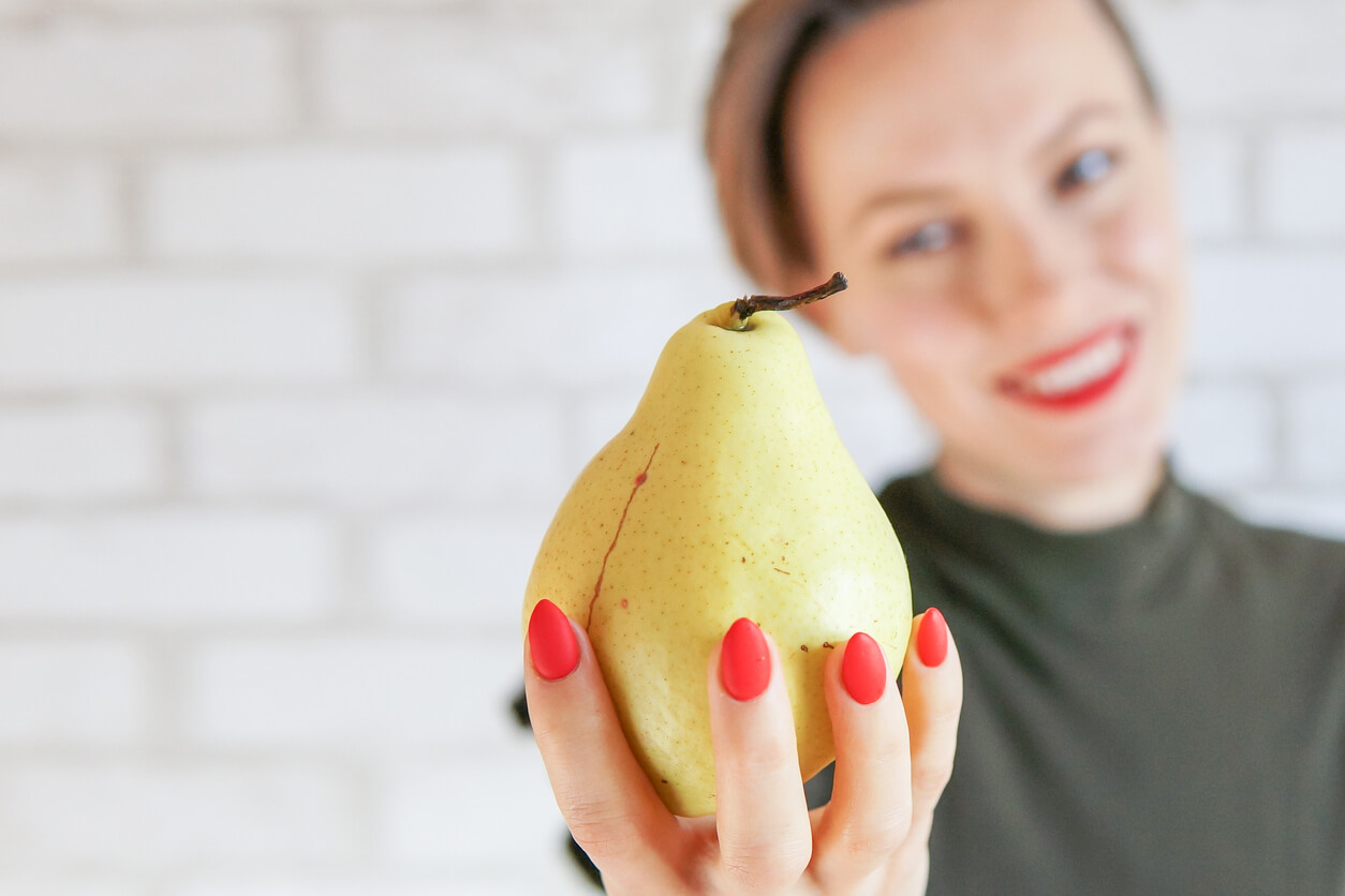 A woman holding a pear.