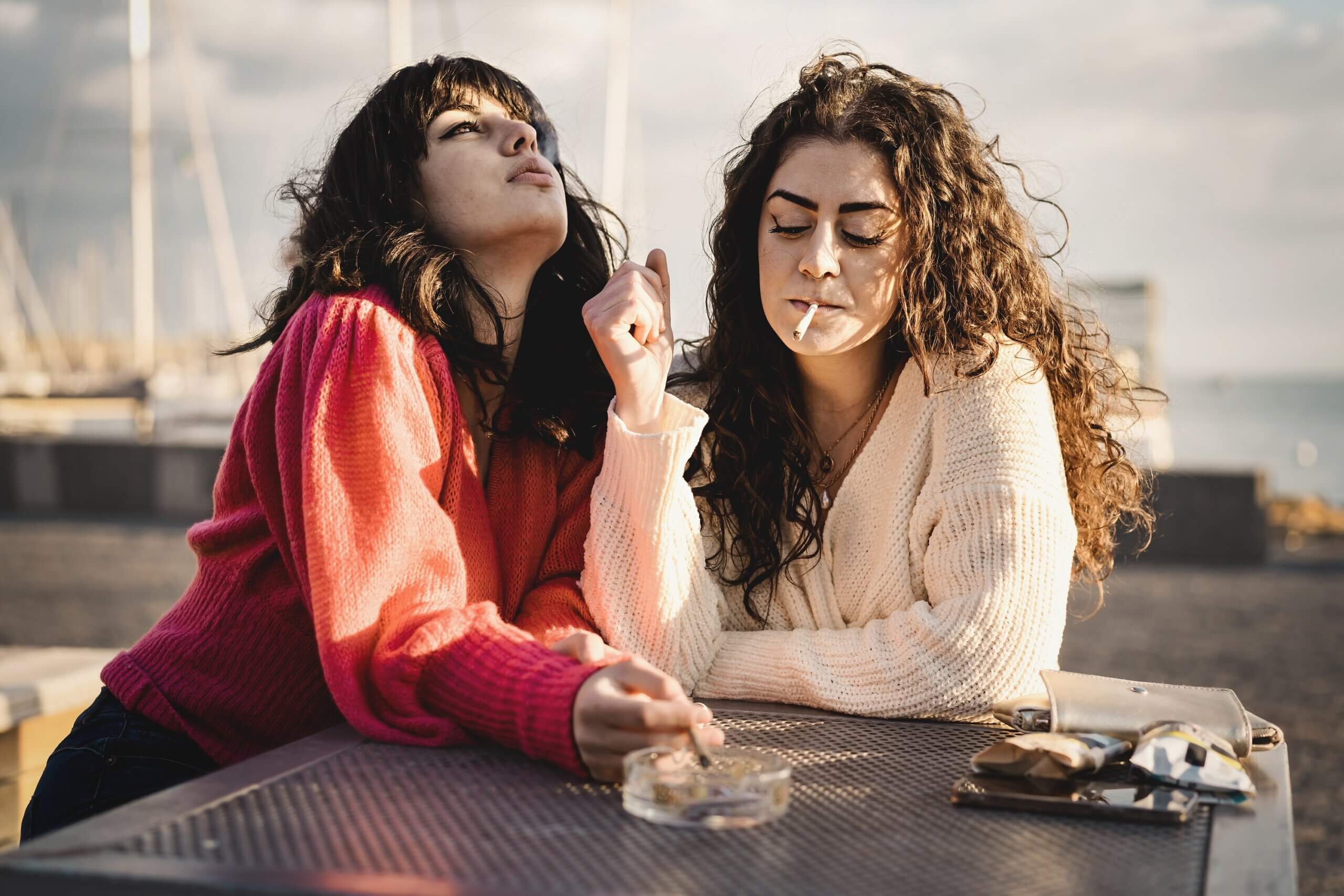 Deux jeunes femmes qui fument une cigarette.