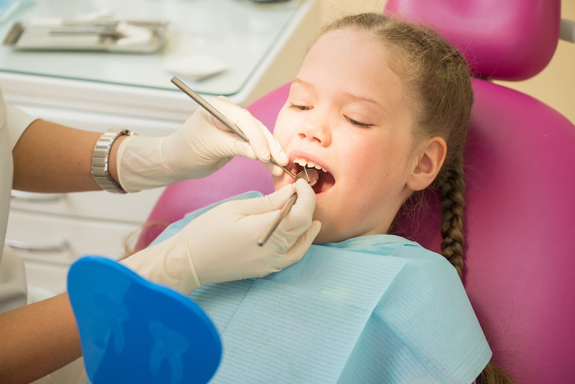 A young girl getting a dental cleaning.