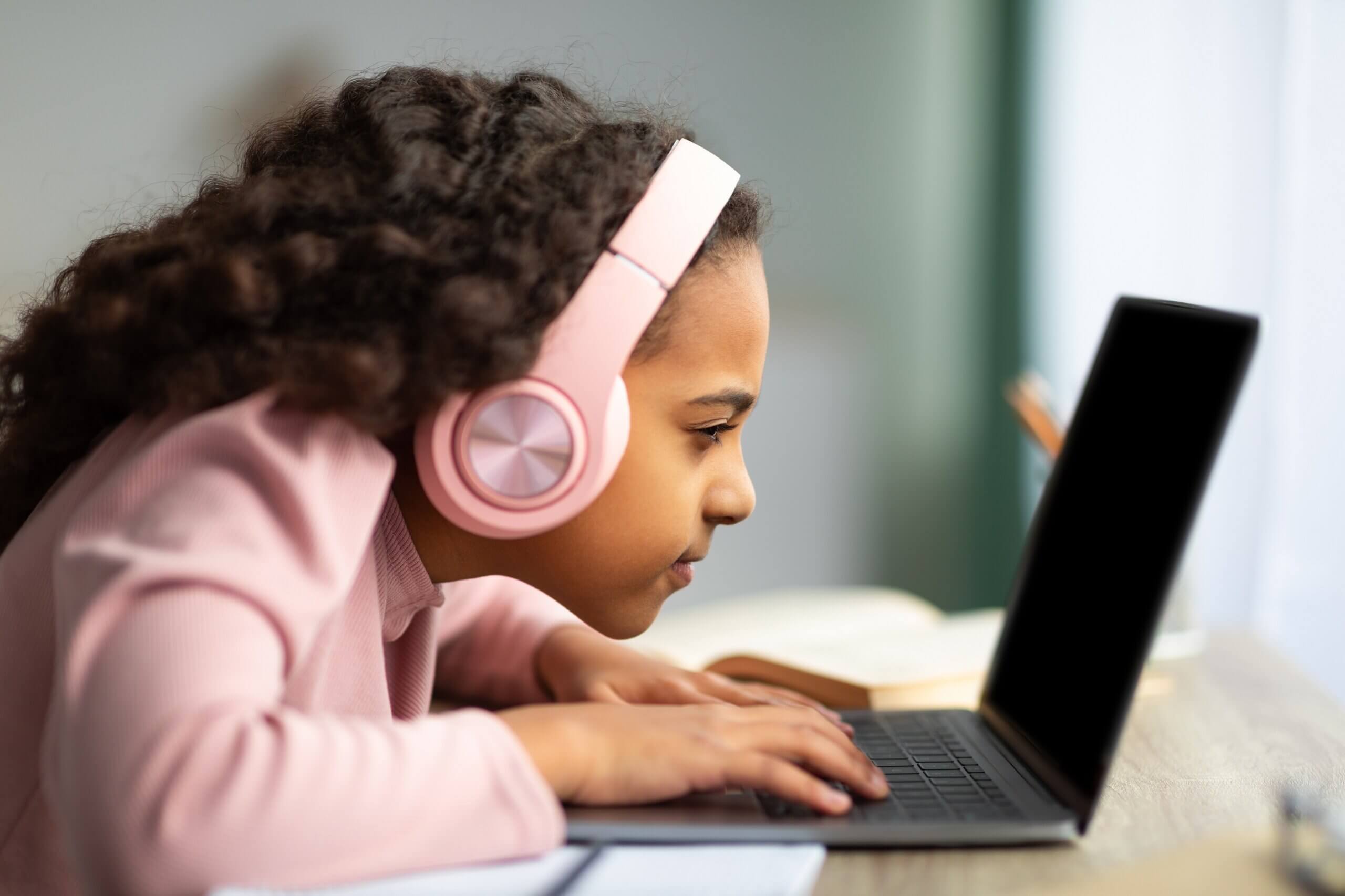 En ung jente som bruker en bærbar datamaskin med ansiktet veldig nært skjermen.