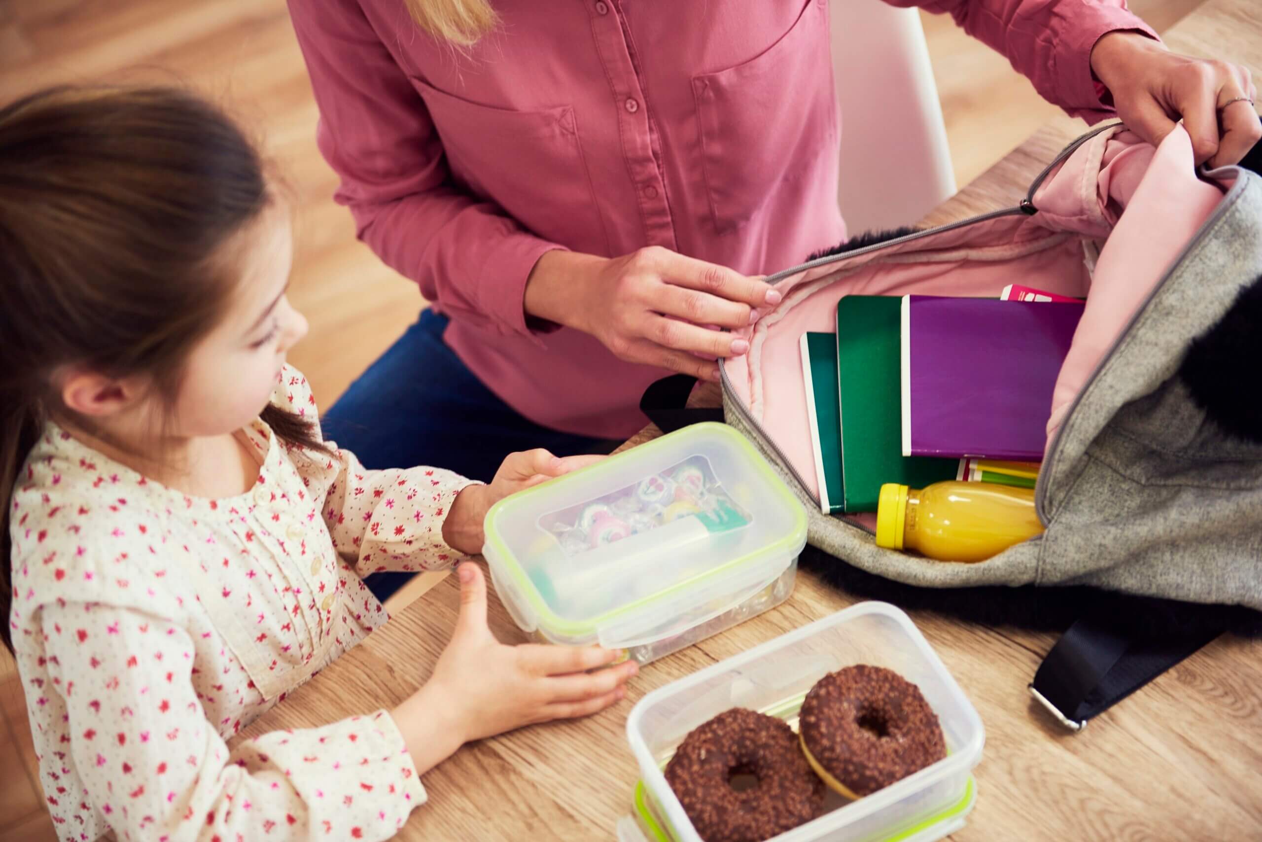 Een kind helpt haar moeder met haar schoolspullen voor te bereiden
