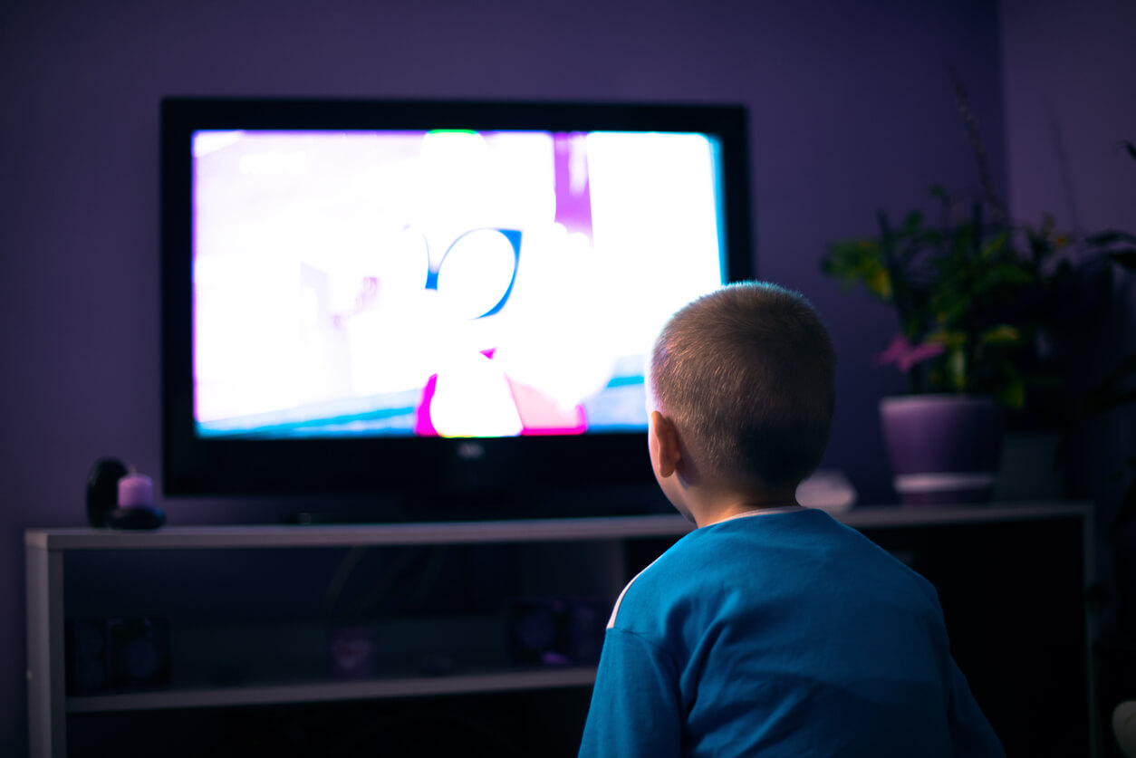 A child watching TV at night.